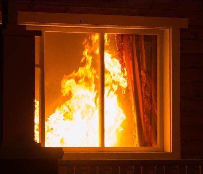 High flames of a fire visible through a window 