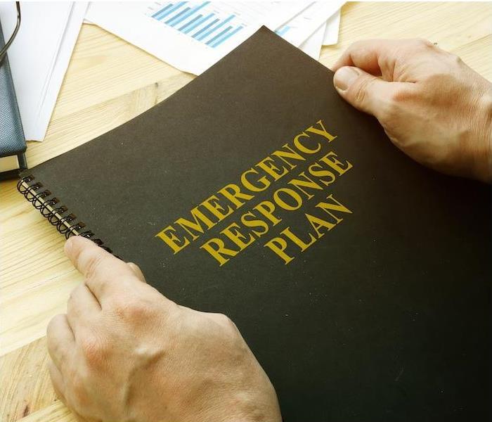 hands holding an emergency response plan book