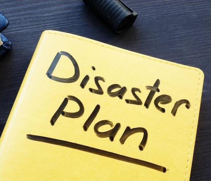 Yellow book with "Disaster Plan" on the front